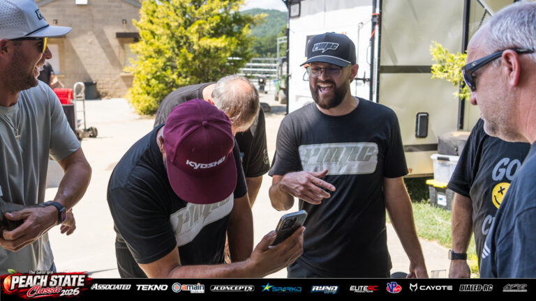 Cole Ogden, Lance MacDonald and Ever Lobos share a laugh with fellow racers around a phone at the 2026 Georgia Peach State Classic. A candid moment from the race weekend’s Good Times photo gallery.
