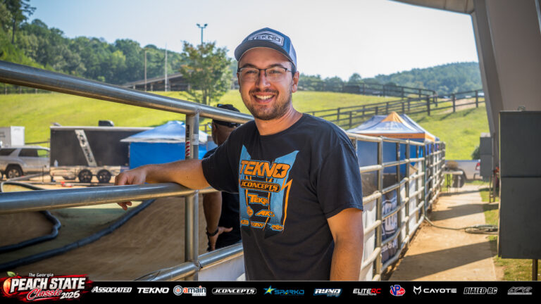 Jared Tebo smiles beside the track railing in a Tekno RC shirt and cap at the 2026 Georgia Peach State Classic. A candid moment from the race weekend’s Good Times photo gallery.