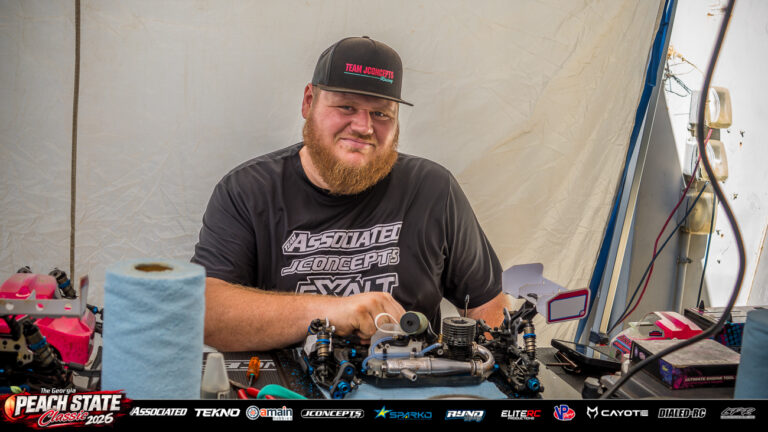 Joshua Vicidomini sits at his pit table with a Team Associated nitro buggy and racing equipment at the 2026 Georgia Peach State Classic. A candid moment from the race weekend’s Good Times photo gallery.